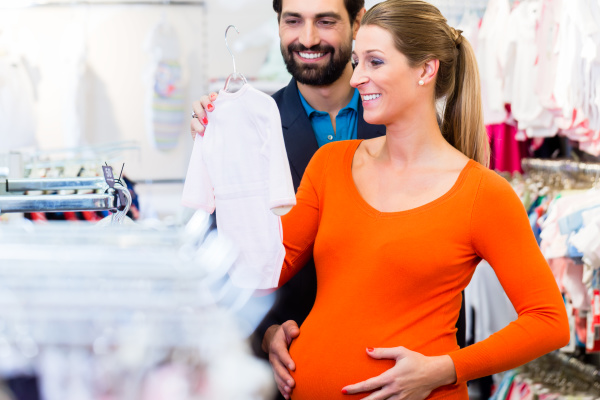 Mujer embarazada y hombre comprando ropa de en - #21501477 | Agencia de stock PantherMedia