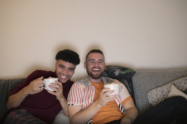 feliz pareja gay masculina bebiendo cacao
