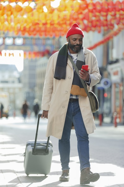 turista masculino con maleta y telefono