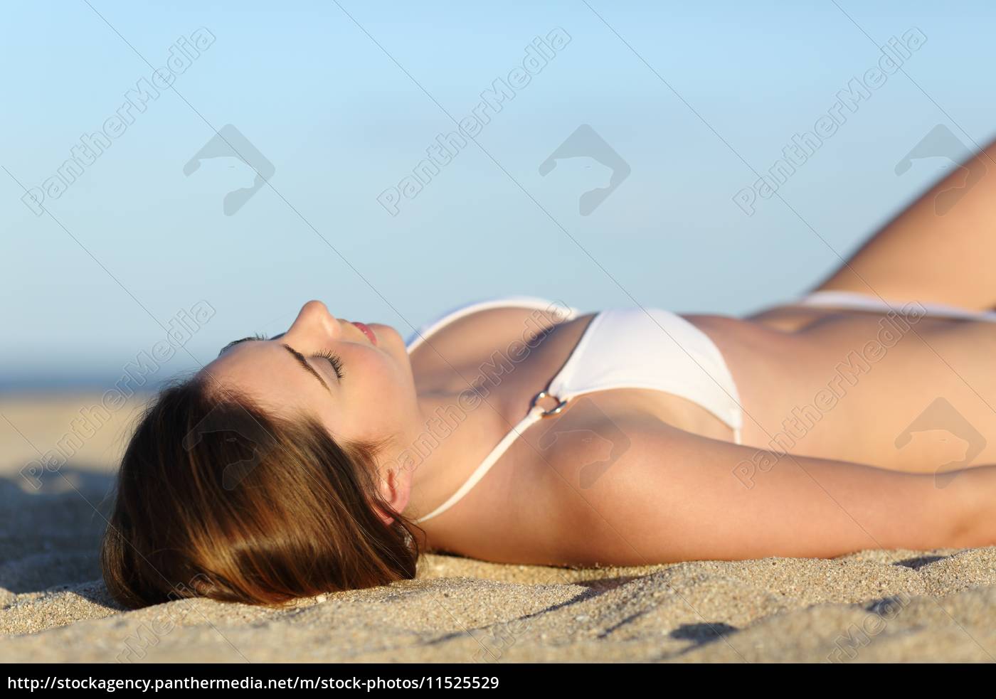 hermosa mujer tomando el sol tumbado en la playa Foto