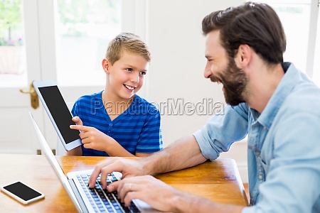 Padre e hijo usando computadora portátil y tableta - Stockphoto #17448664 |  Agencia de stock PantherMedia