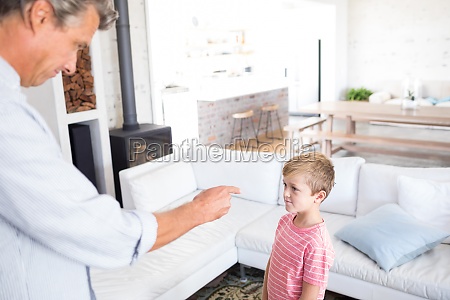 Padre enojado regañando a su hijo en la sala de estar - Foto de archivo  #23095567 | Agencia de stock PantherMedia